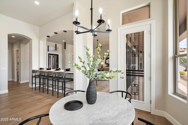 34599 N 99th Way, Scottsdale, AZ 85262 - dining area with a chandelier, arched walkways, wood finished floors, and baseboards
