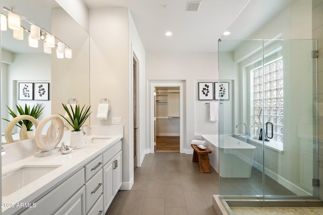 34599 N 99th Way, Scottsdale, AZ 85262 - bathroom featuring double vanity, a stall shower, a freestanding bath, baseboards, and tile patterned floors