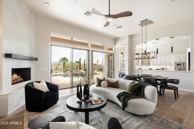 34599 N 99th Way, Scottsdale, AZ 85262 - living area with ceiling fan, a chandelier, wood finished floors, a fireplace, and recessed lighting