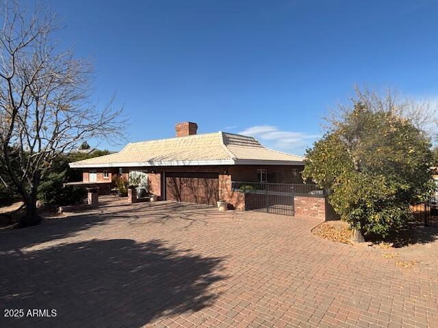 view of front of home with a chimney and fence