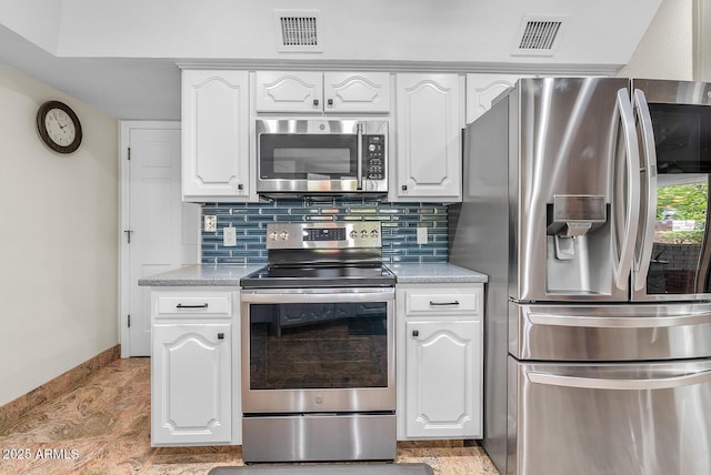 kitchen with stainless steel appliances, visible vents, and decorative backsplash