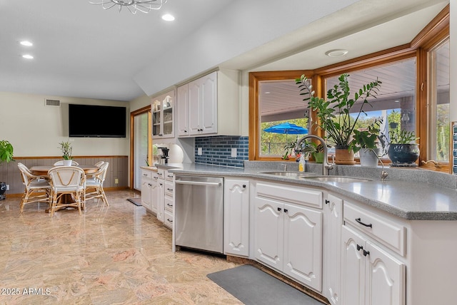 kitchen featuring a sink, visible vents, white cabinetry, stainless steel dishwasher, and wainscoting