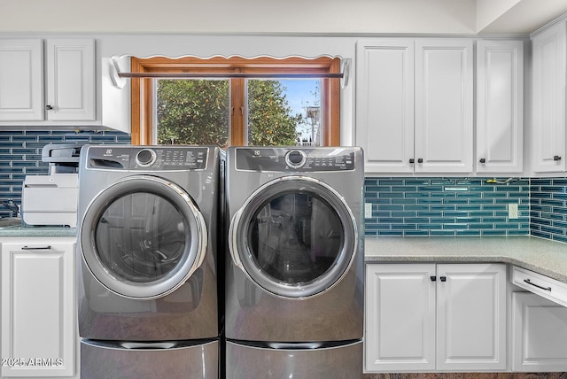 laundry area with washing machine and dryer and cabinet space