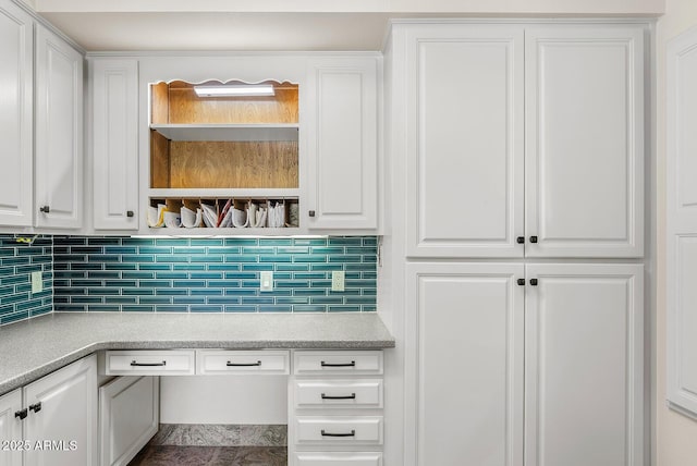 kitchen featuring built in desk, open shelves, tasteful backsplash, light countertops, and white cabinetry