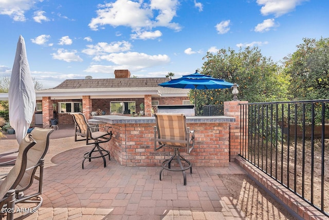 view of patio / terrace featuring fence and exterior bar