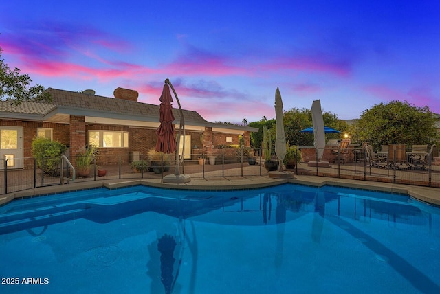 outdoor pool with fence and a patio