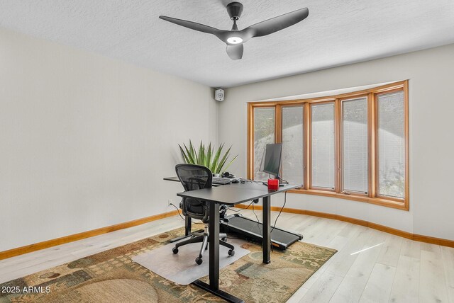 office area with ceiling fan, a textured ceiling, baseboards, and wood finished floors