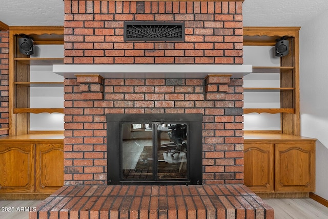 room details featuring a brick fireplace and wood finished floors