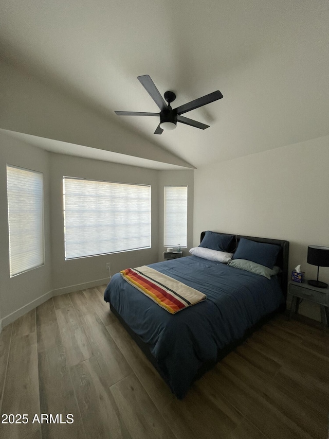 bedroom with hardwood / wood-style flooring, vaulted ceiling, and ceiling fan