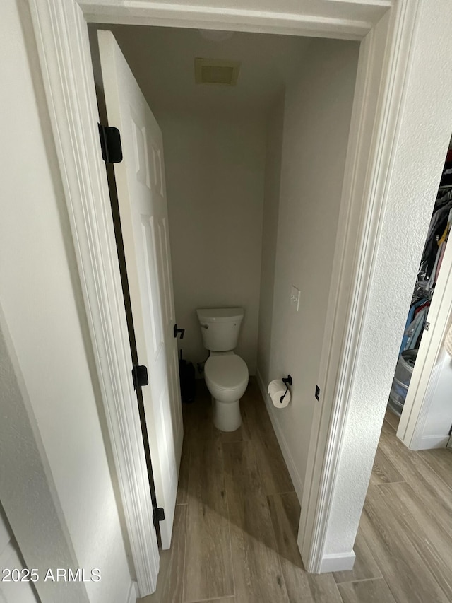 bathroom featuring hardwood / wood-style flooring and toilet