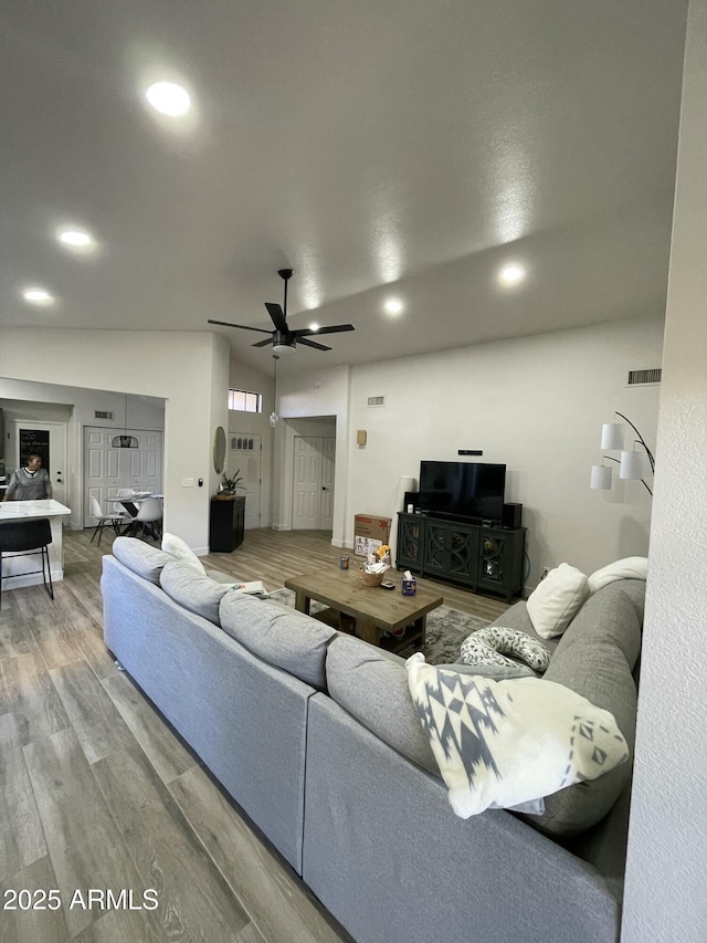 living room featuring wood-type flooring and ceiling fan