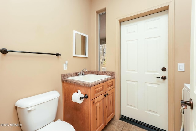 bathroom featuring vanity, toilet, and tile patterned flooring