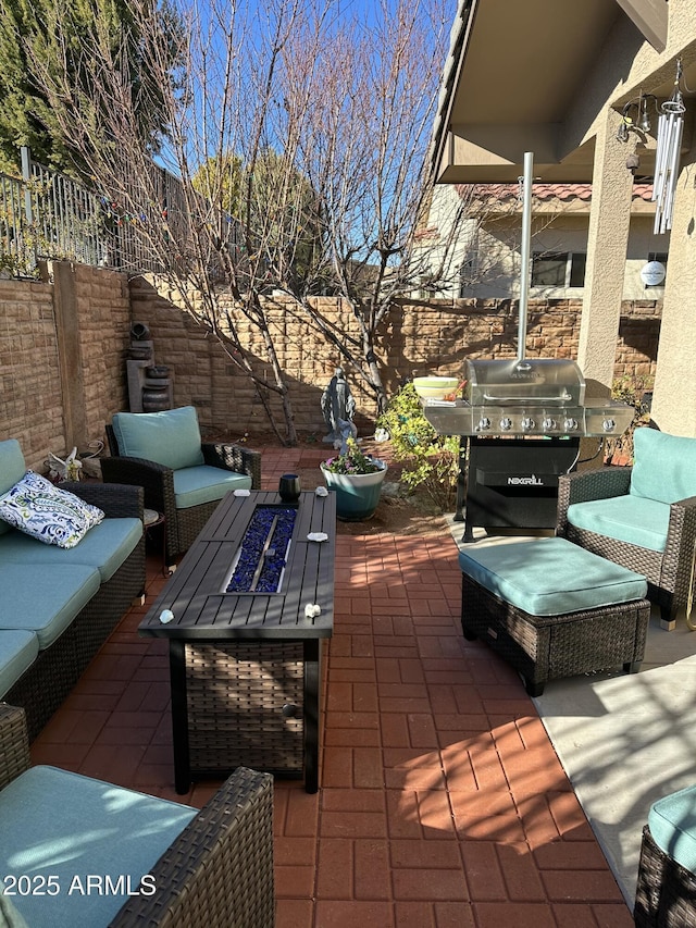 view of patio with a grill and an outdoor living space with a fire pit