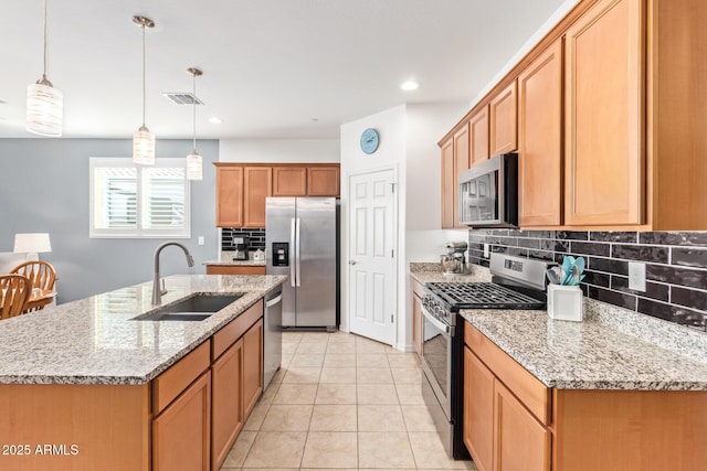28883 N 131st Dr, Peoria, AZ 85383 - kitchen with stainless steel appliances, an island with sink, a sink, and pendant lighting