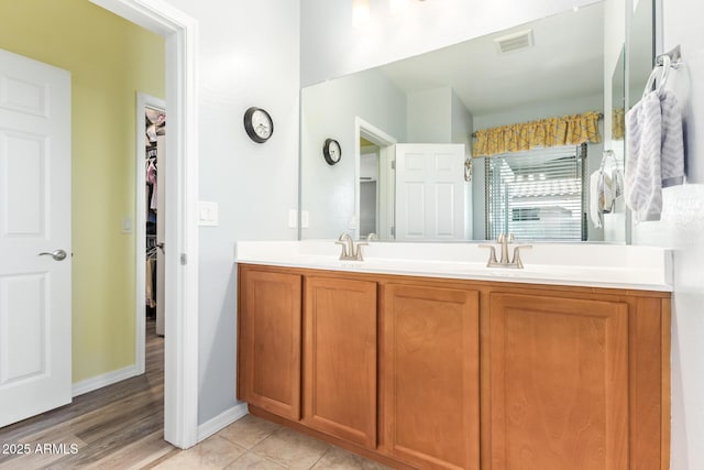 28883 N 131st Dr, Peoria, AZ 85383 - bathroom featuring double vanity, a spacious closet, visible vents, and a sink