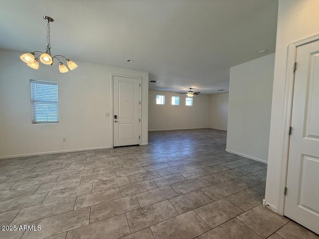 unfurnished room featuring ceiling fan with notable chandelier and light tile patterned floors