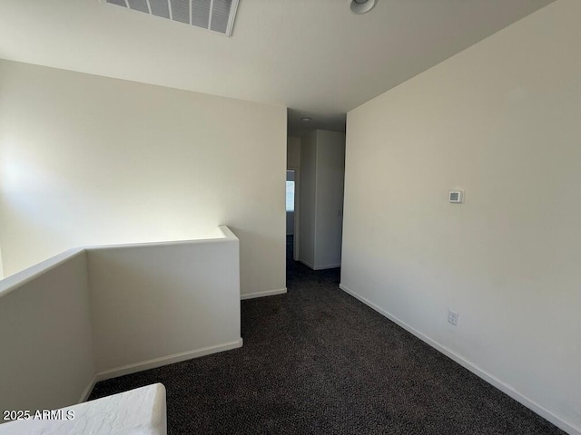 empty room with dark colored carpet