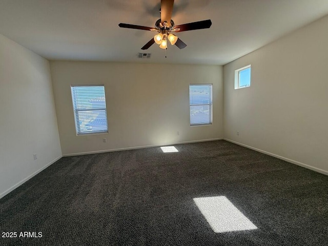 empty room with ceiling fan and dark carpet