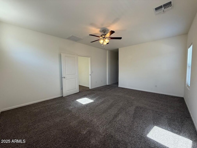 spare room with dark colored carpet and ceiling fan