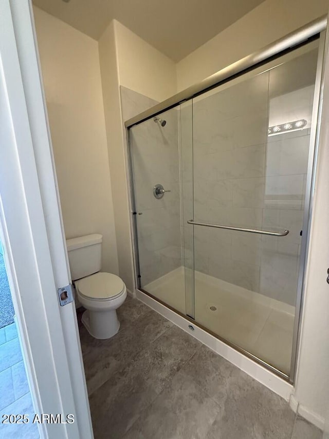 bathroom featuring an enclosed shower and toilet