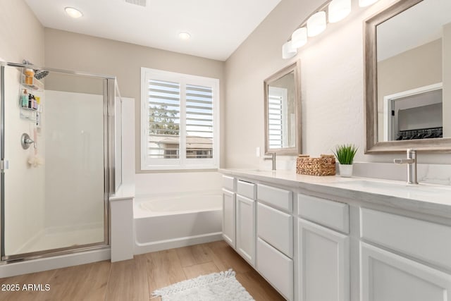 6870 S Crestview Dr, Gilbert, AZ 85298 - bathroom with a stall shower, a bath, wood finished floors, double vanity, and recessed lighting