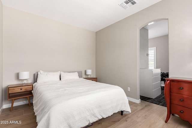 6870 S Crestview Dr, Gilbert, AZ 85298 - bedroom with arched walkways, light wood-style floors, and baseboards