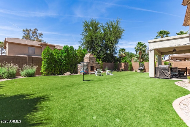 6870 S Crestview Dr, Gilbert, AZ 85298 - view of yard featuring an outdoor stone fireplace, a ceiling fan, and a patio
