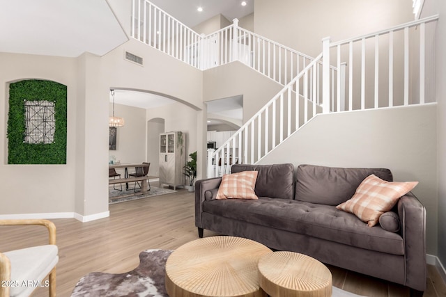 6870 S Crestview Dr, Gilbert, AZ 85298 - living area with arched walkways, wood finished floors, a high ceiling, recessed lighting, and stairway