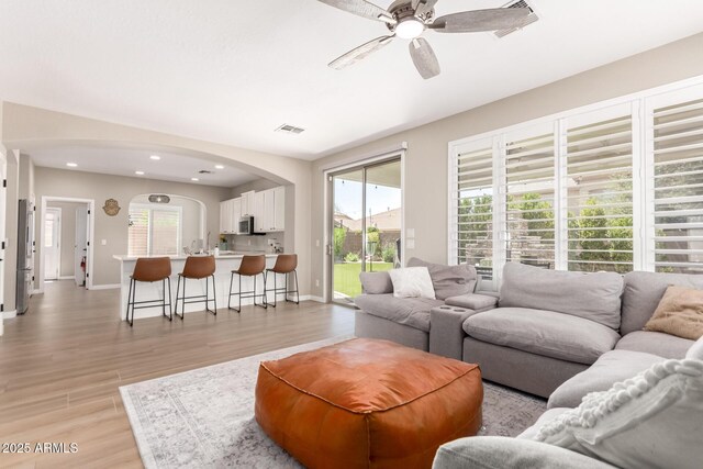 6870 S Crestview Dr, Gilbert, AZ 85298 - living room featuring arched walkways, ceiling fan, light wood-type flooring, recessed lighting, and baseboards