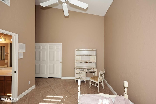 unfurnished bedroom with ceiling fan, light tile patterned flooring, ensuite bathroom, and high vaulted ceiling