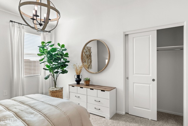 bedroom with an inviting chandelier, baseboards, a closet, and light carpet