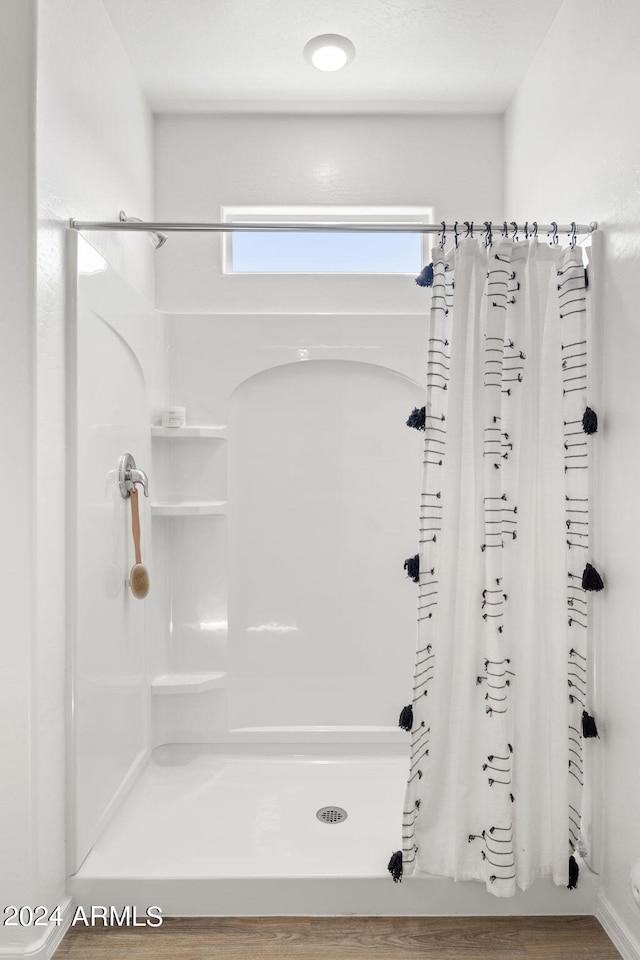 bathroom with a shower with shower curtain and wood finished floors