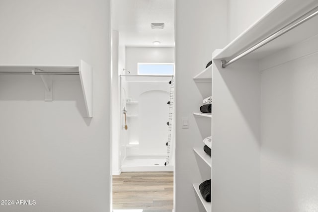 walk in closet with wood finished floors