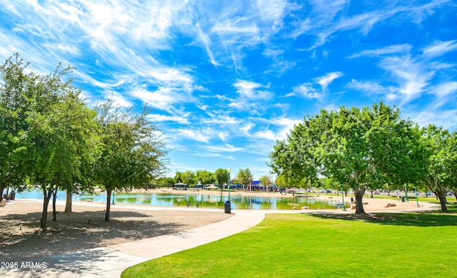 view of property's community with a lawn and a water view