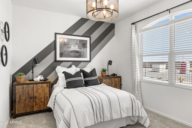 carpeted bedroom featuring baseboards and an inviting chandelier