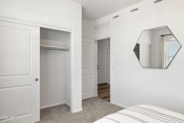 bedroom featuring a closet, visible vents, baseboards, and carpet