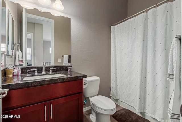 full bathroom featuring a textured wall, vanity, a shower with shower curtain, and toilet