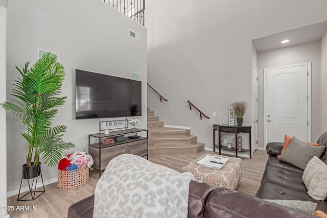 living area featuring visible vents, baseboards, recessed lighting, wood finished floors, and stairway