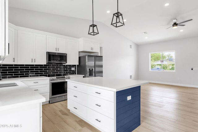2122 W Virginia Ave, Phoenix, AZ 85009 - kitchen featuring stainless steel appliances, backsplash, open floor plan, light countertops, and a kitchen island