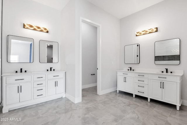 2122 W Virginia Ave, Phoenix, AZ 85009 - bathroom featuring marble look tile flooring, double vanity, and baseboards