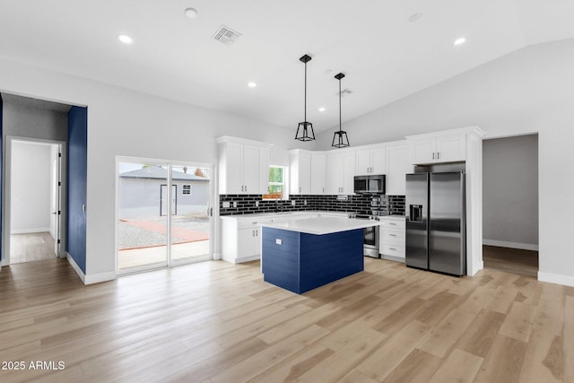 2122 W Virginia Ave, Phoenix, AZ 85009 - kitchen with appliances with stainless steel finishes, a kitchen island, decorative backsplash, light countertops, and white cabinetry