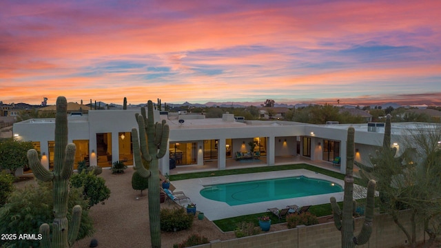 pool at dusk with a patio