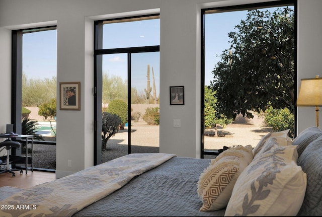 bedroom with wood-type flooring and access to exterior