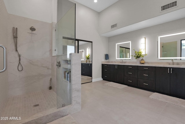 bathroom with vanity, a towering ceiling, and a shower with shower door