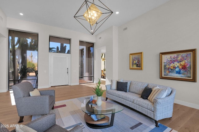 living room with a notable chandelier and light hardwood / wood-style flooring