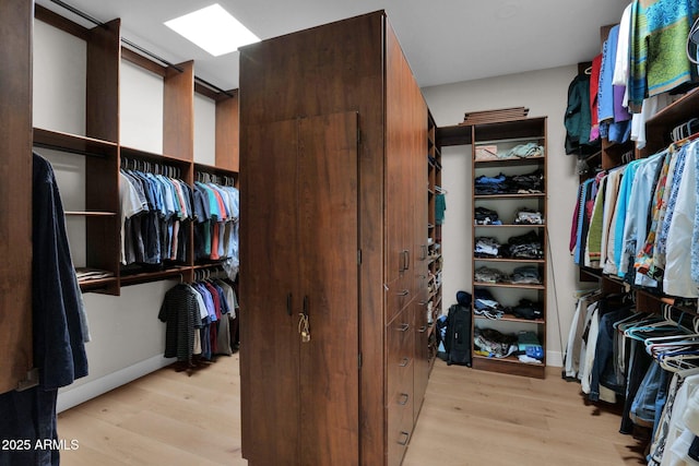 walk in closet featuring a skylight and light wood-type flooring