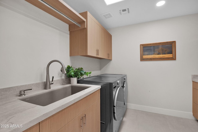 washroom with cabinets, separate washer and dryer, sink, and light tile patterned floors