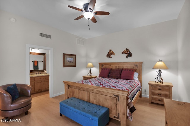 bedroom with ensuite bathroom, sink, and light hardwood / wood-style floors