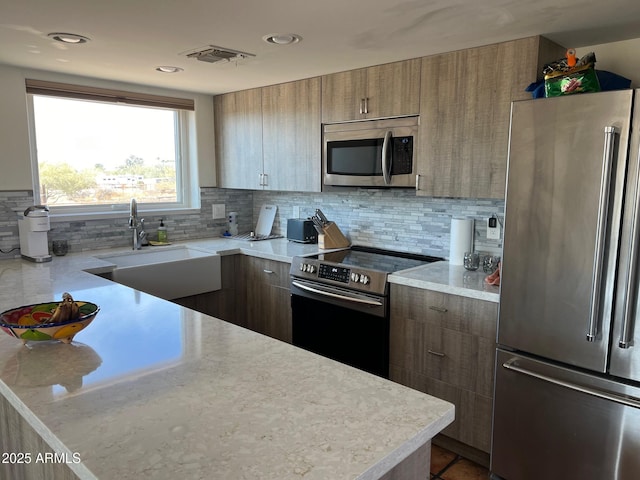 kitchen with stainless steel appliances, sink, and decorative backsplash