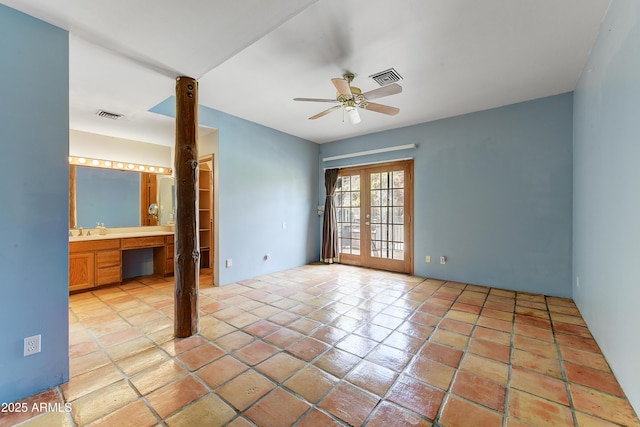 empty room featuring a ceiling fan, french doors, visible vents, and a sink